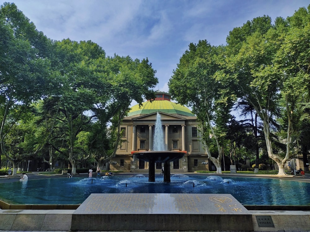 une fontaine au milieu d’un parc entouré d’arbres