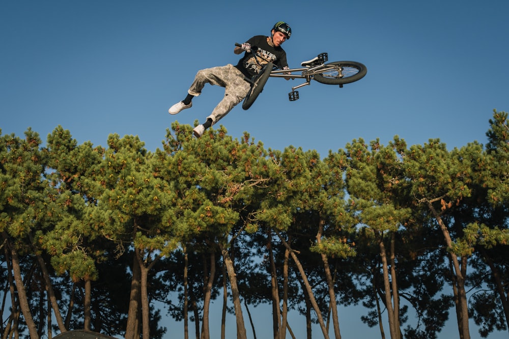 a man flying through the air while riding a bike