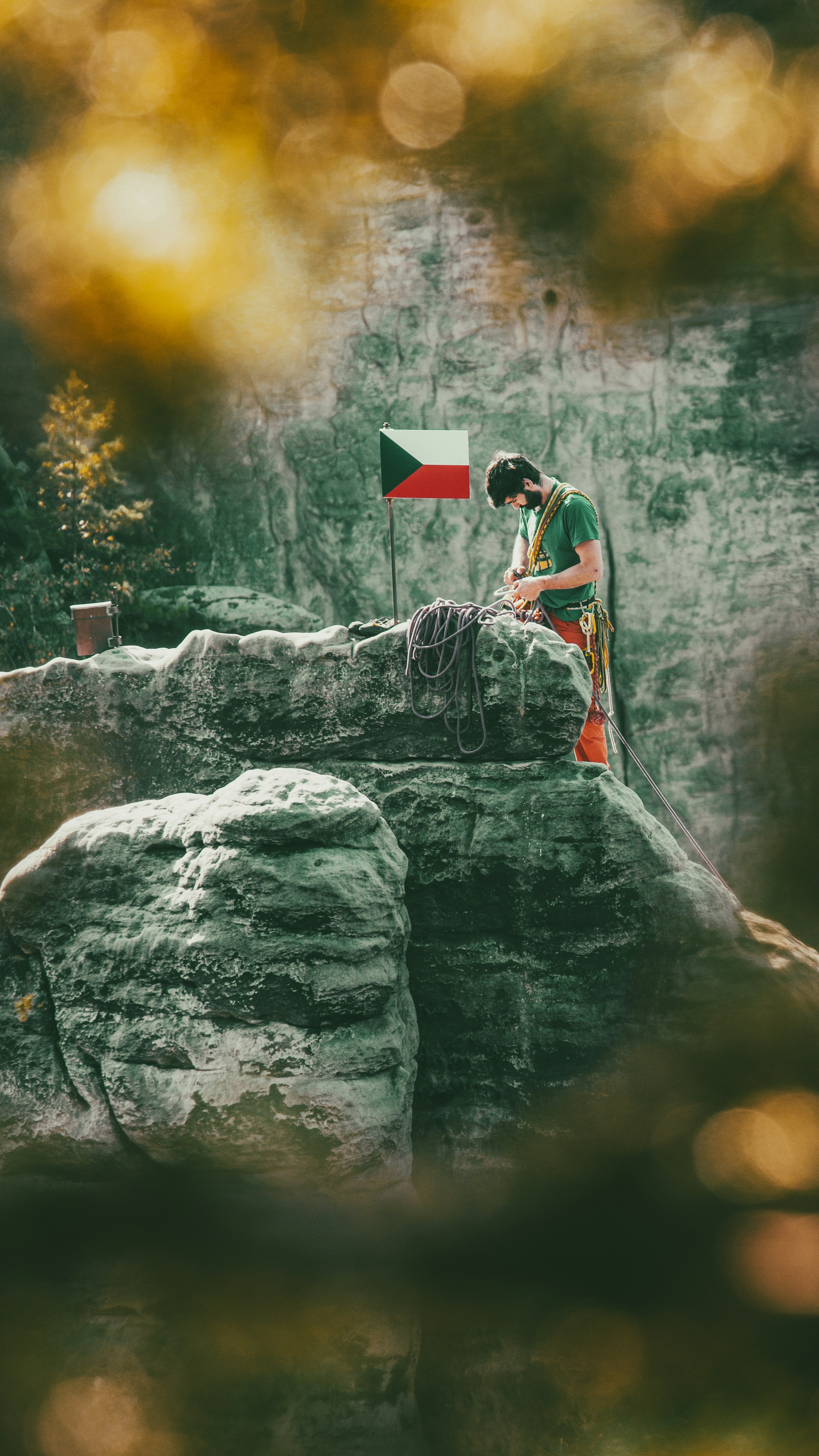 a man sitting on top of a rock next to a flag