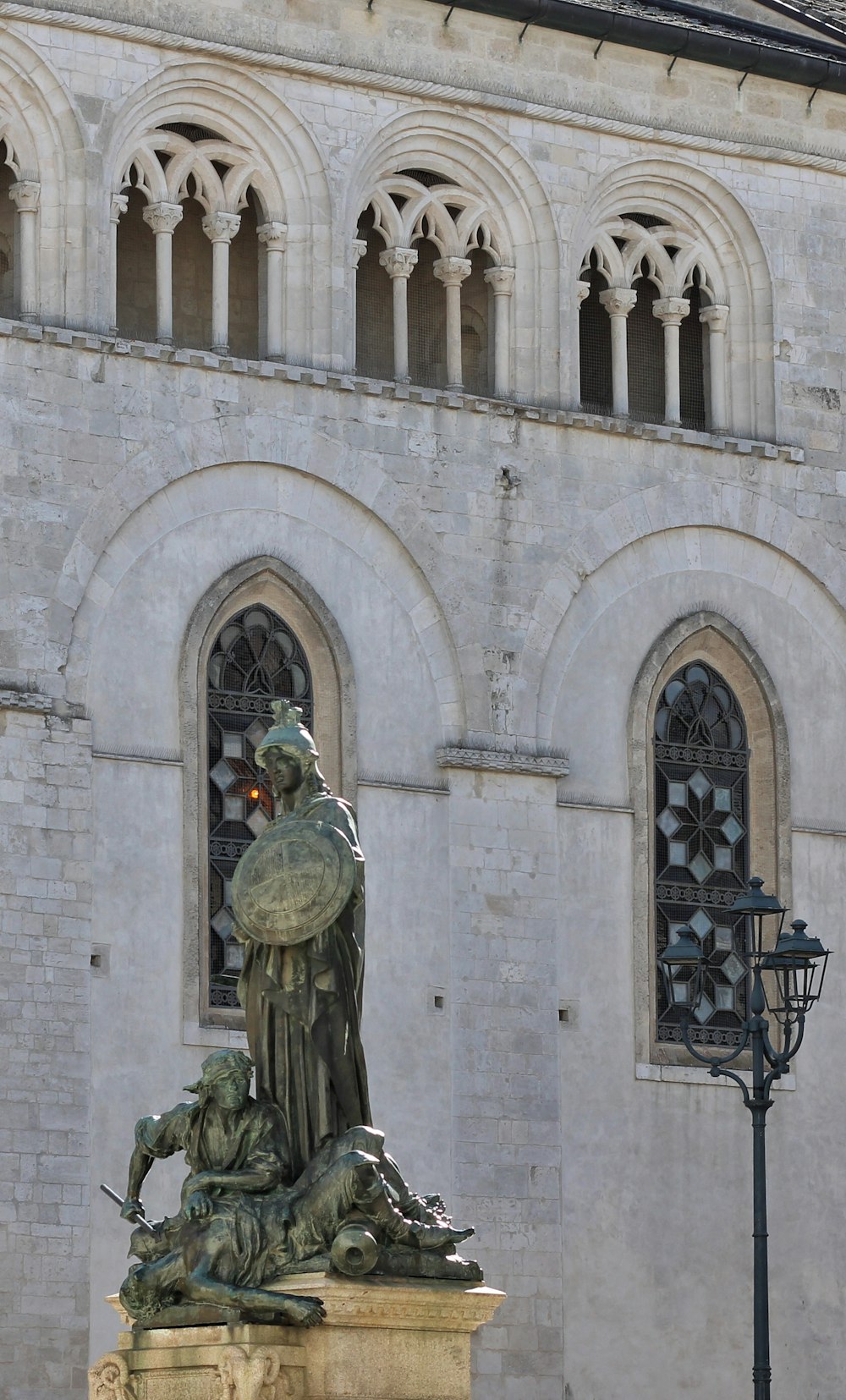 a statue of a man holding a bird in front of a building