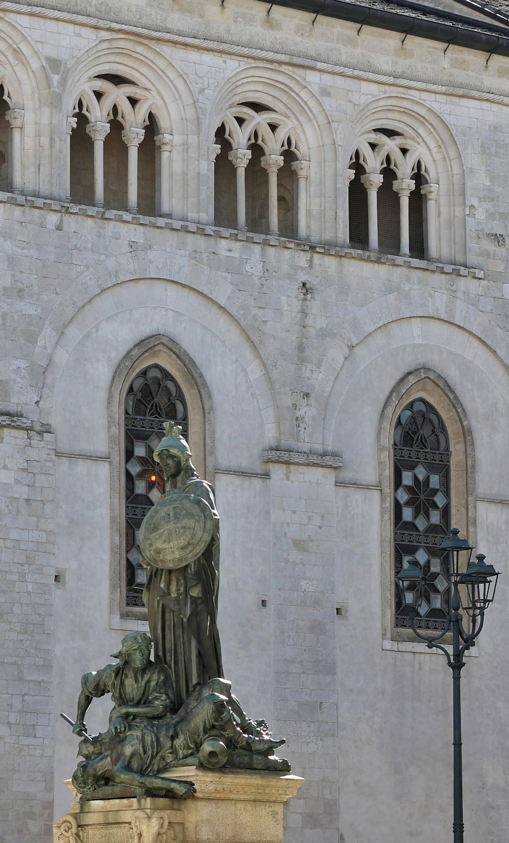 une statue d’un homme tenant un oiseau devant un bâtiment