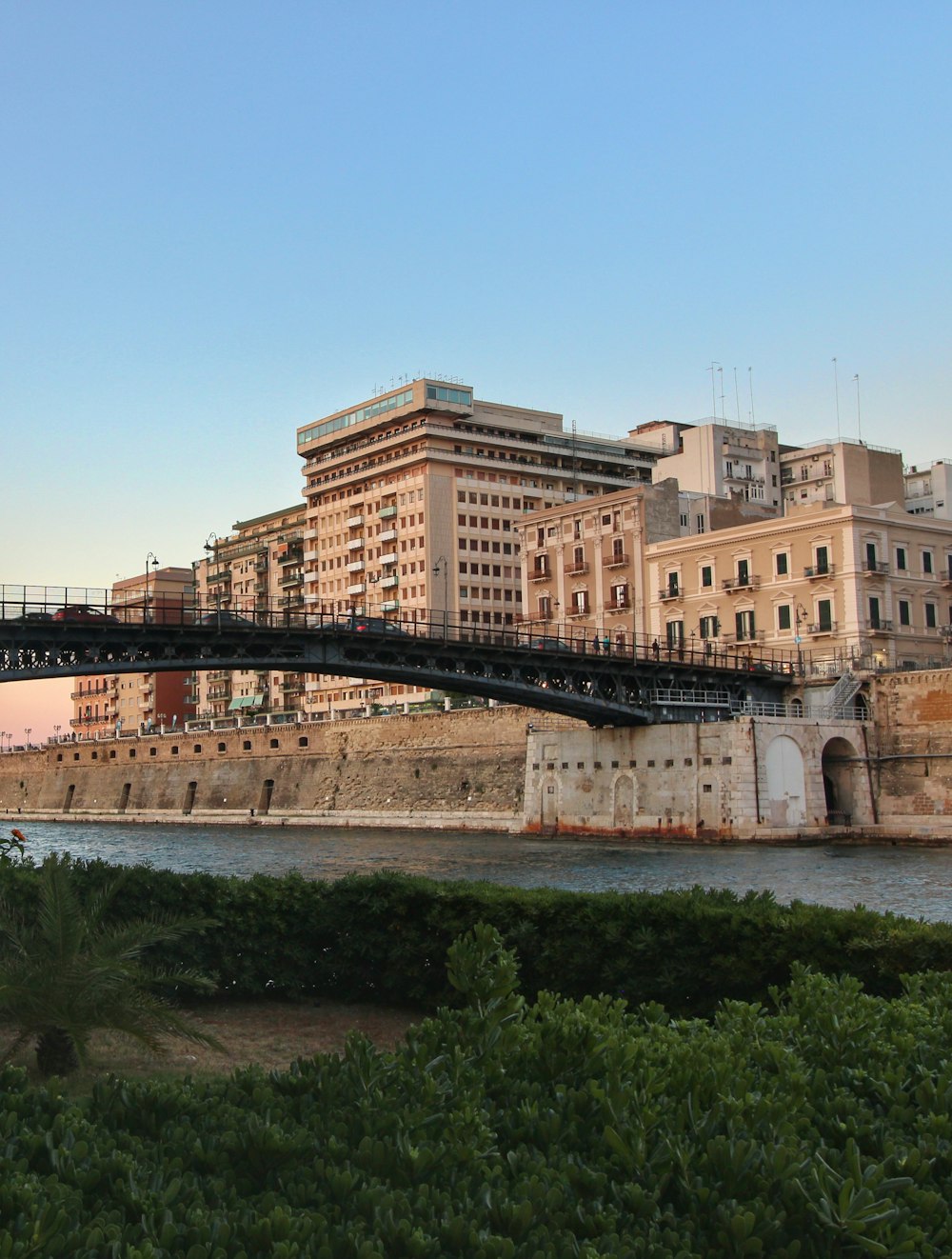 eine Brücke über ein Gewässer mit Gebäuden im Hintergrund