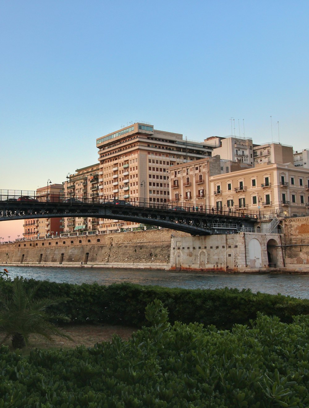 a bridge over a body of water with buildings in the background