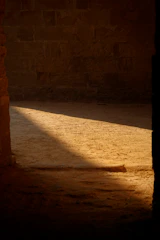 Soft lighting highlighting natural stone walls and wooden beams overhead.