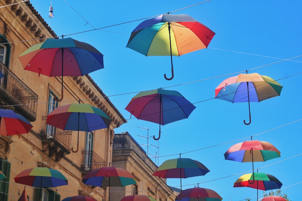 a group of multicolored umbrellas hanging from wires