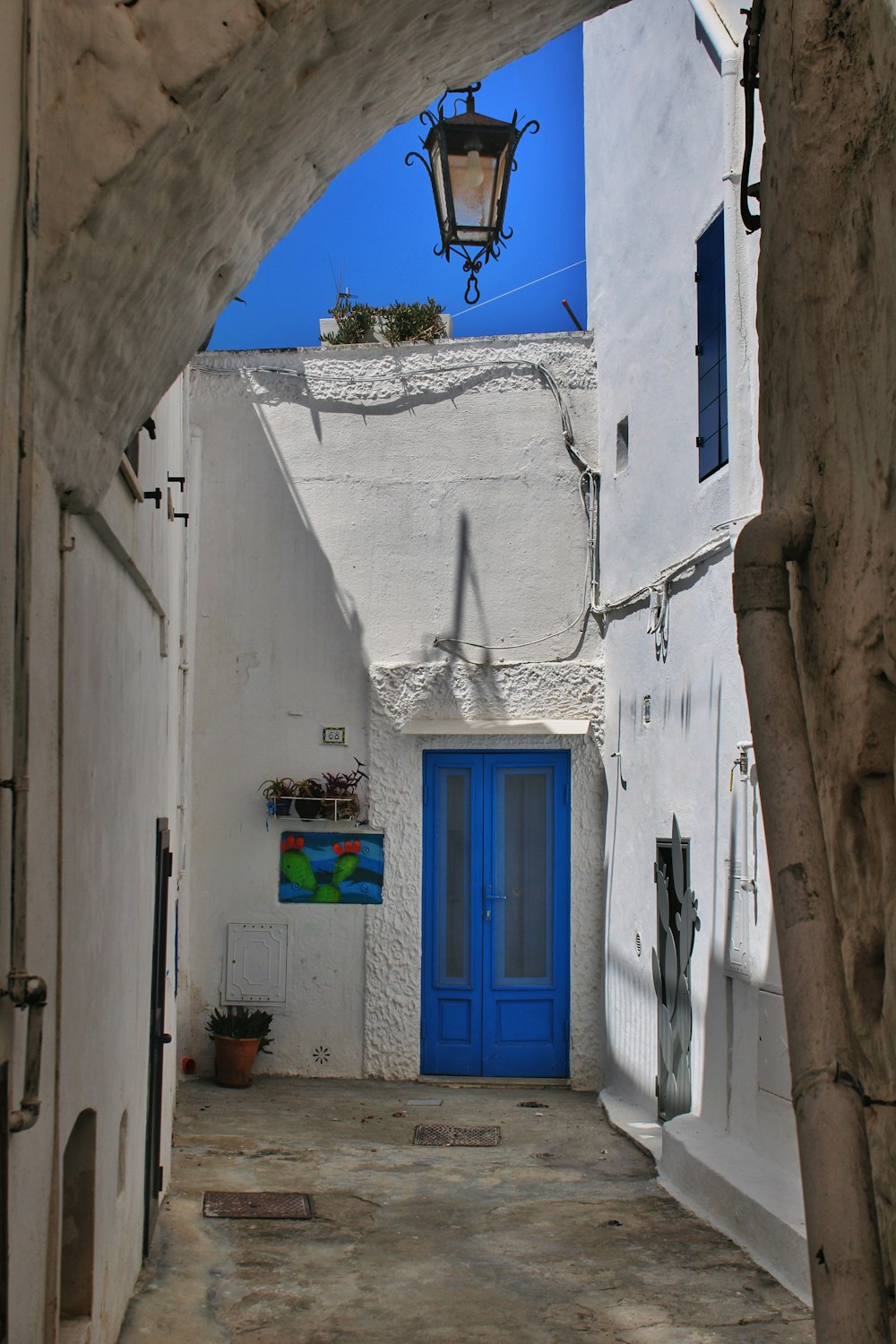 a narrow alleyway with a blue door