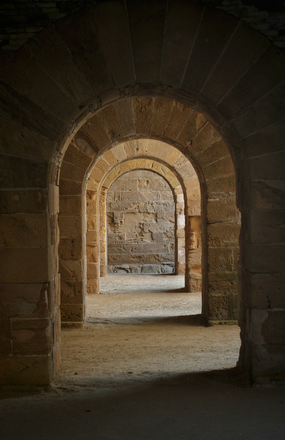 an archway in a stone building with light coming through
