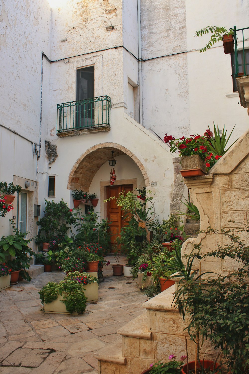 a building with a bunch of potted plants in front of it