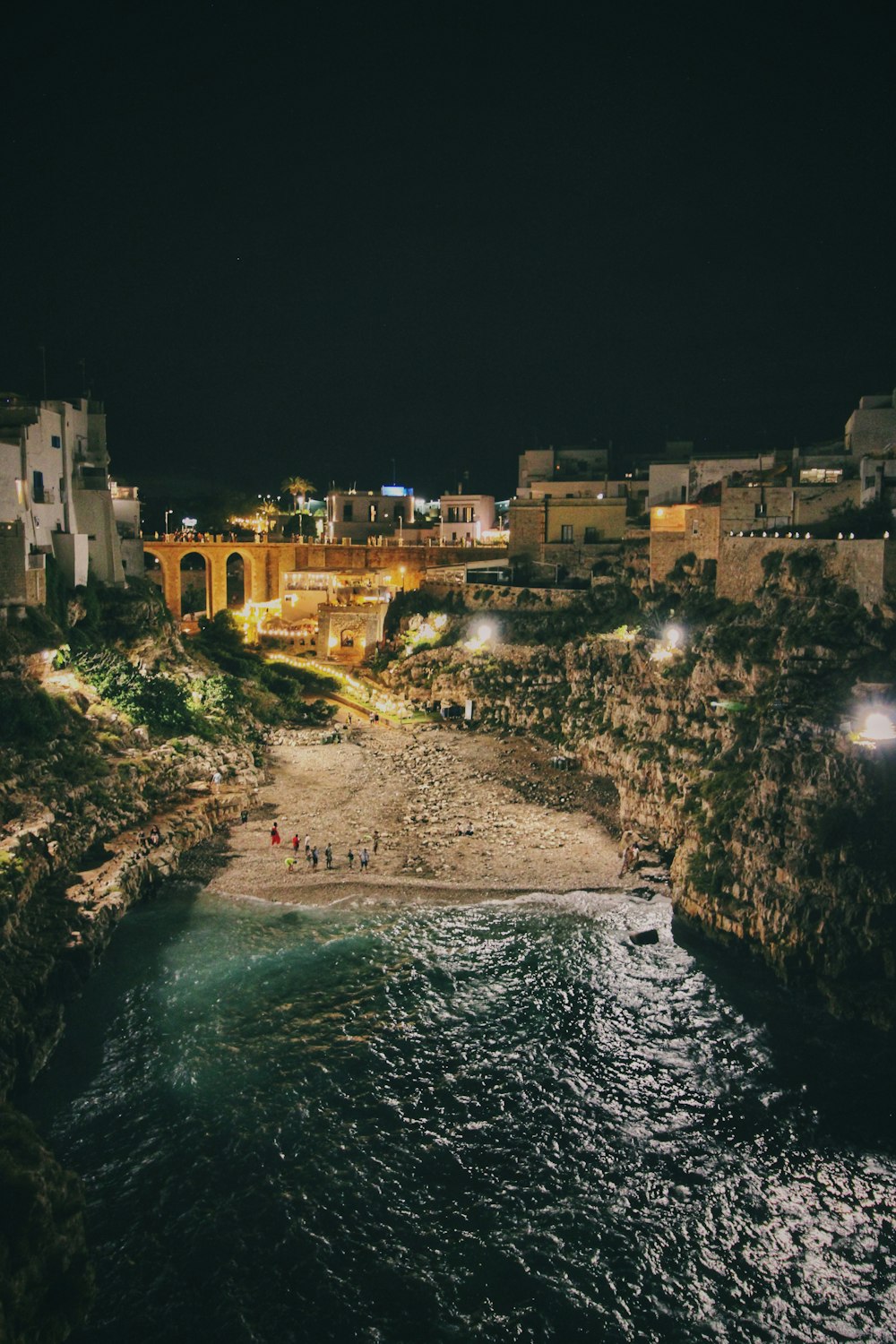 a night view of a beach with a city in the background