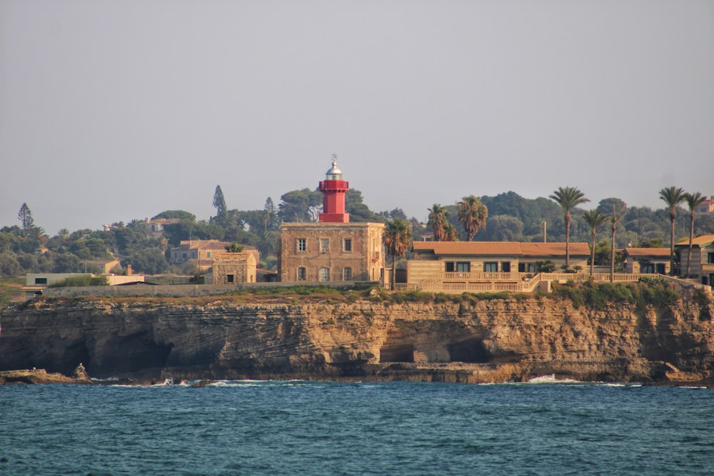 a lighthouse on top of a cliff next to a body of water