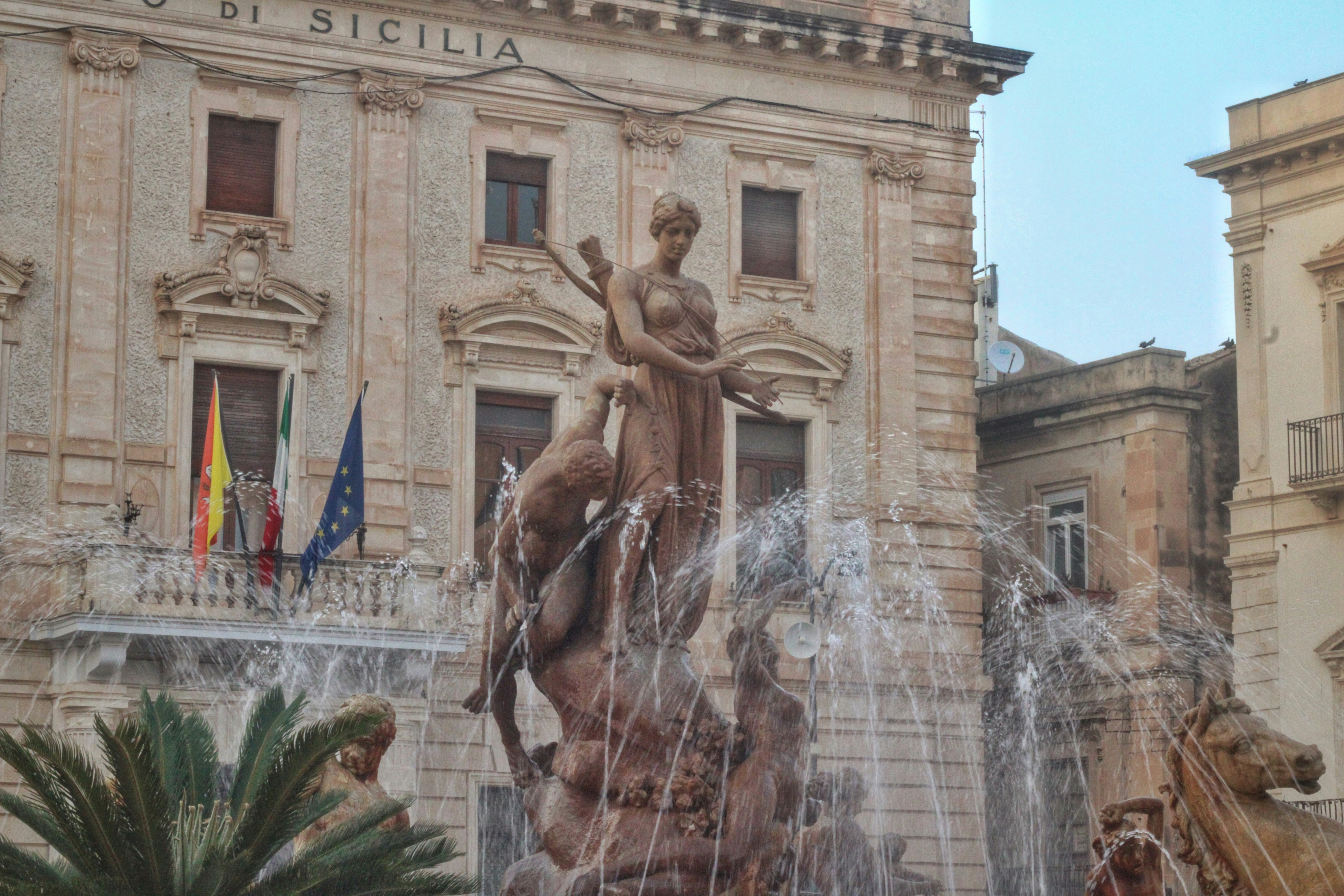 a fountain in front of a large building, 