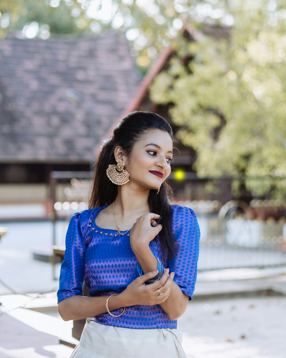 a woman in a blue top and white skirt