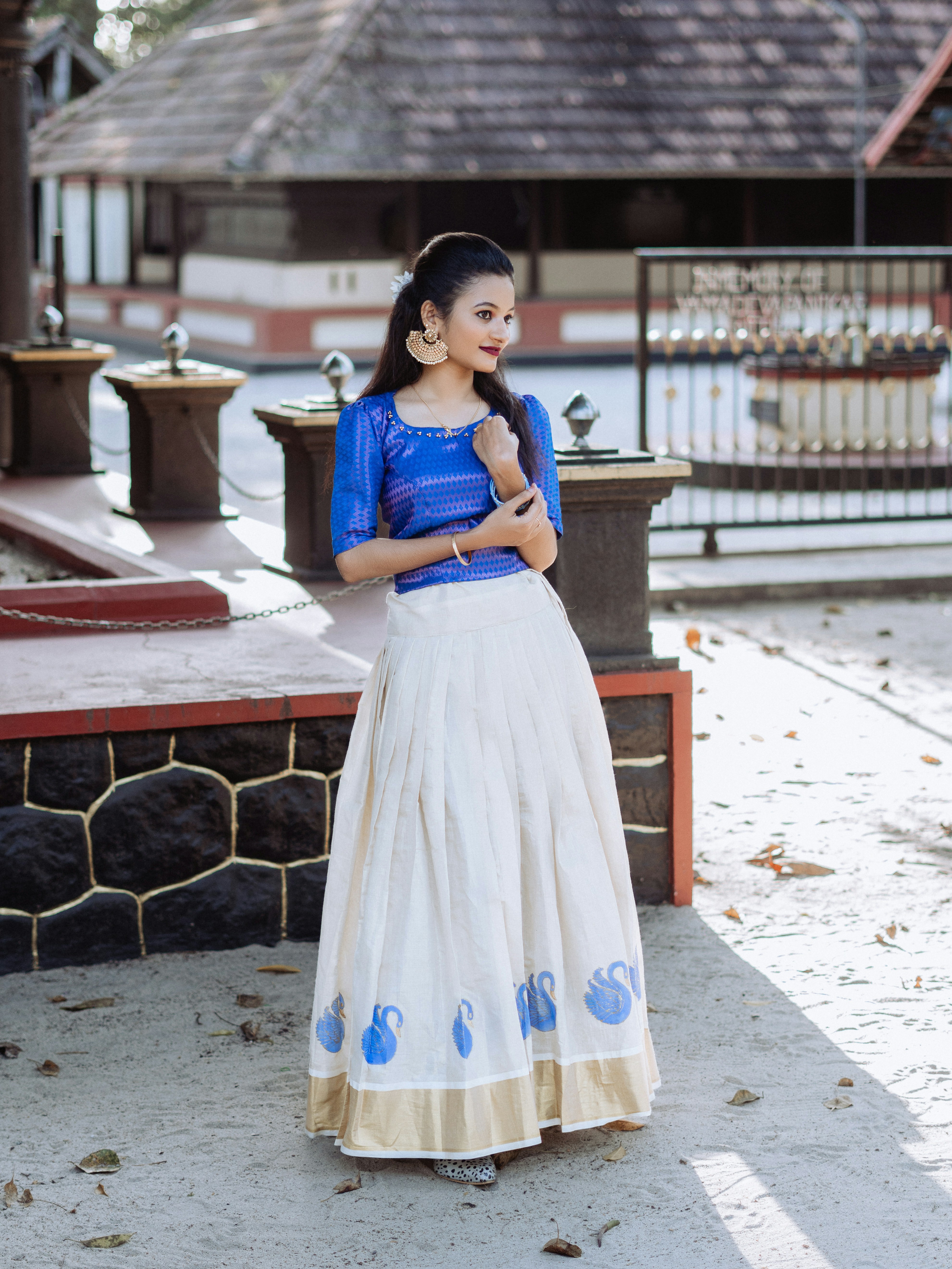 a woman in a blue top and white skirt