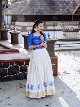 a woman in a blue top and white skirt