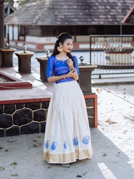 a woman in a blue top and white skirt