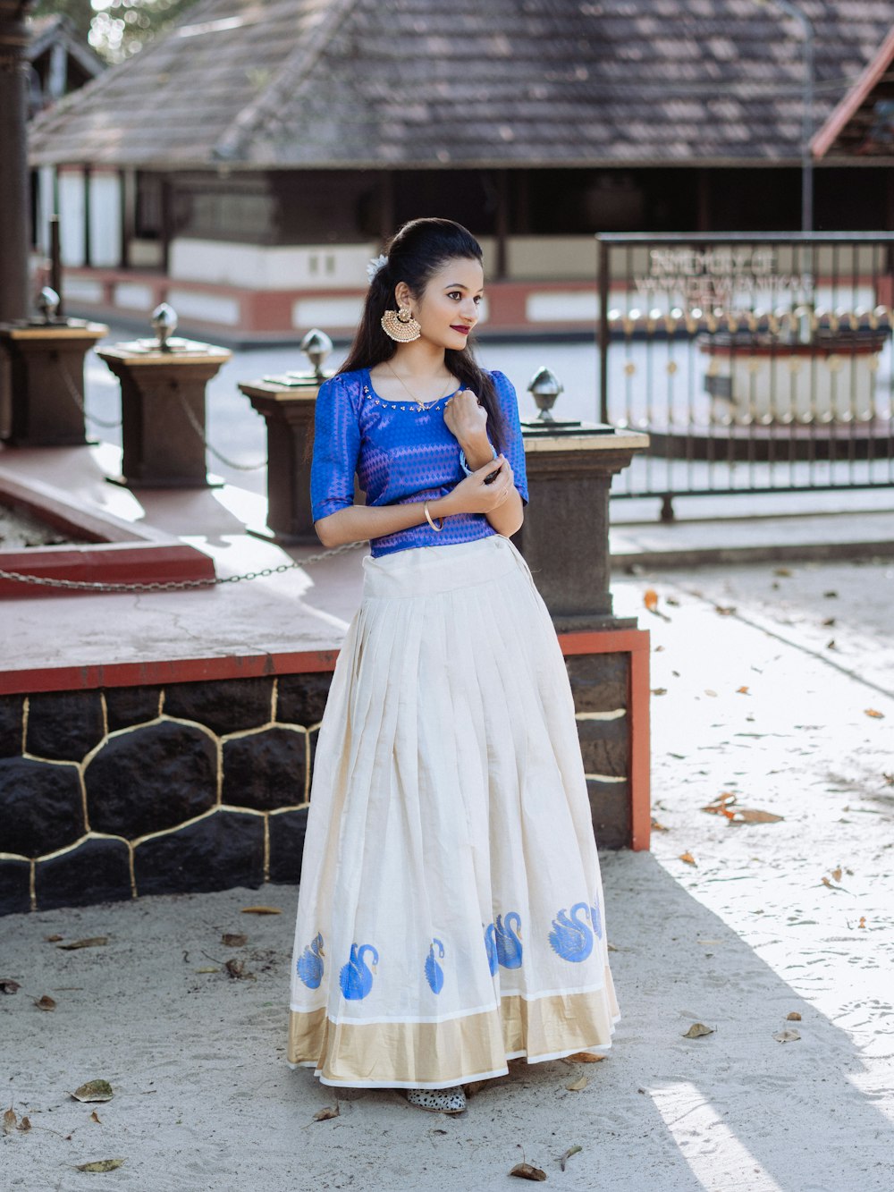a woman in a blue top and white skirt