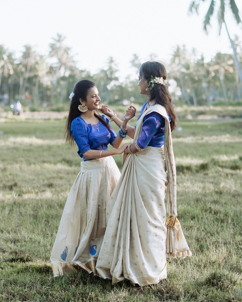 two women standing next to each other in a field