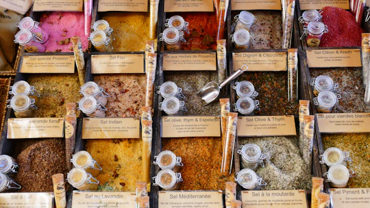 Colorful jars of dried spices arranged neatly with traditional Senegalese cooking tools