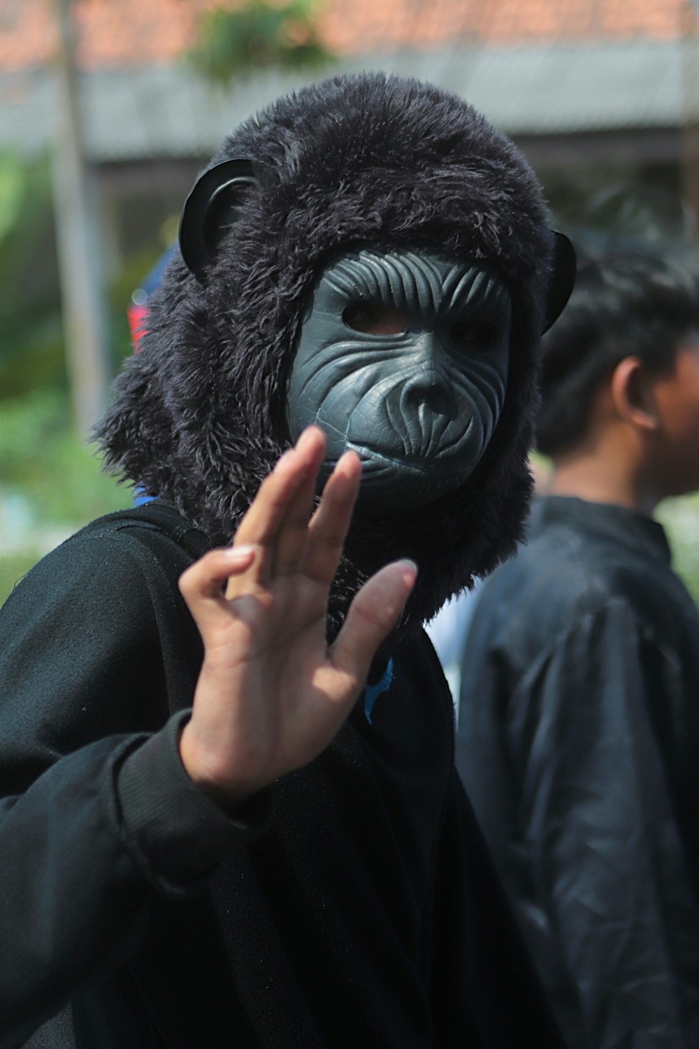 a person wearing a gorilla mask and making a hand gesture