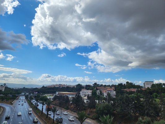 A scenic view of a highway with cars driving under a clear blue sky.