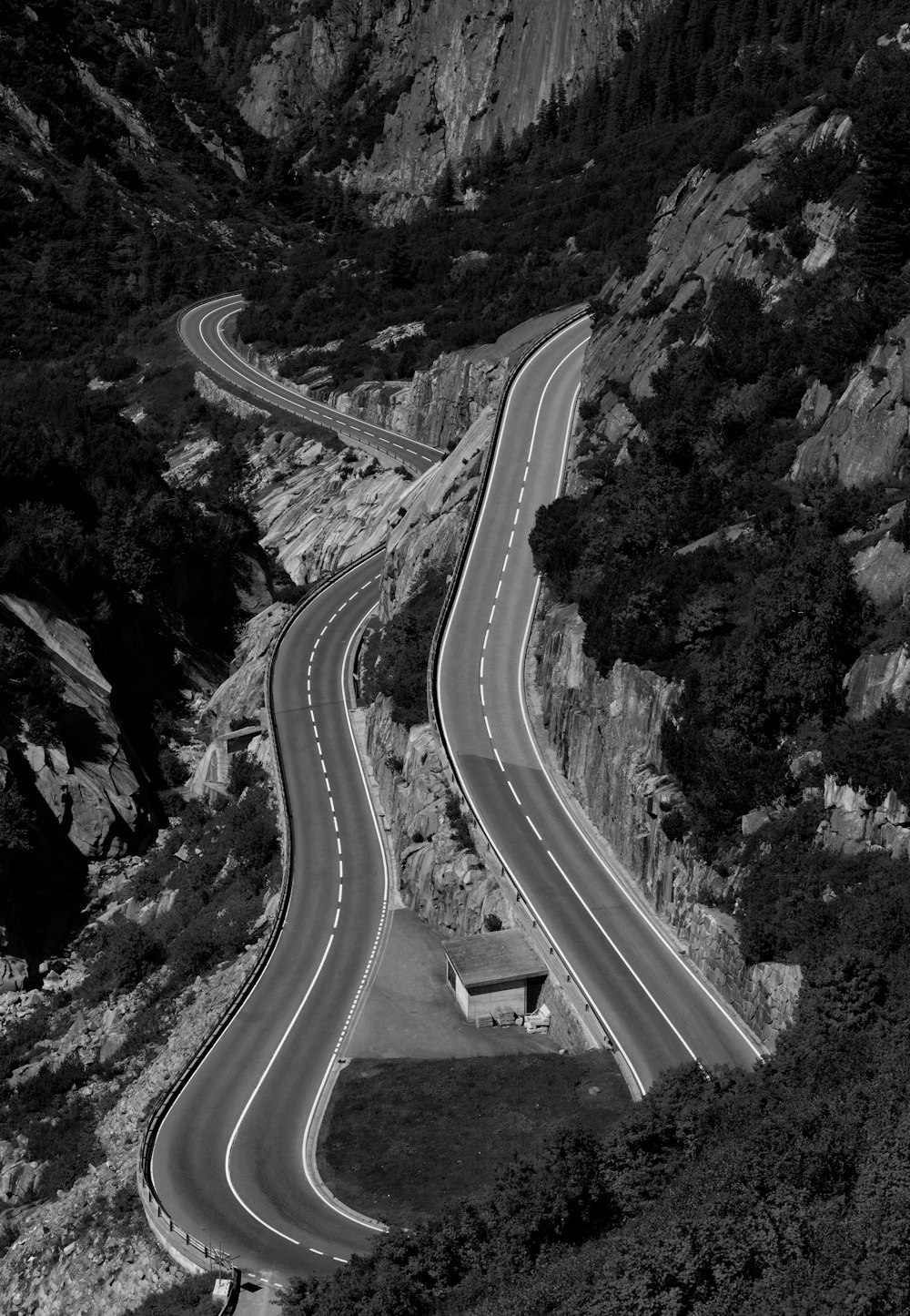 a black and white photo of a winding road