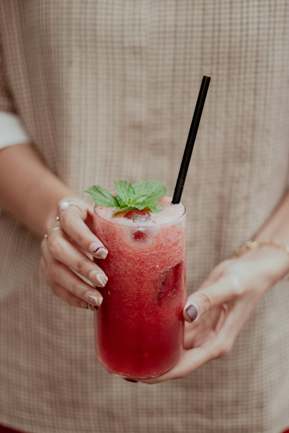 a woman holding a drink with a straw in her hand