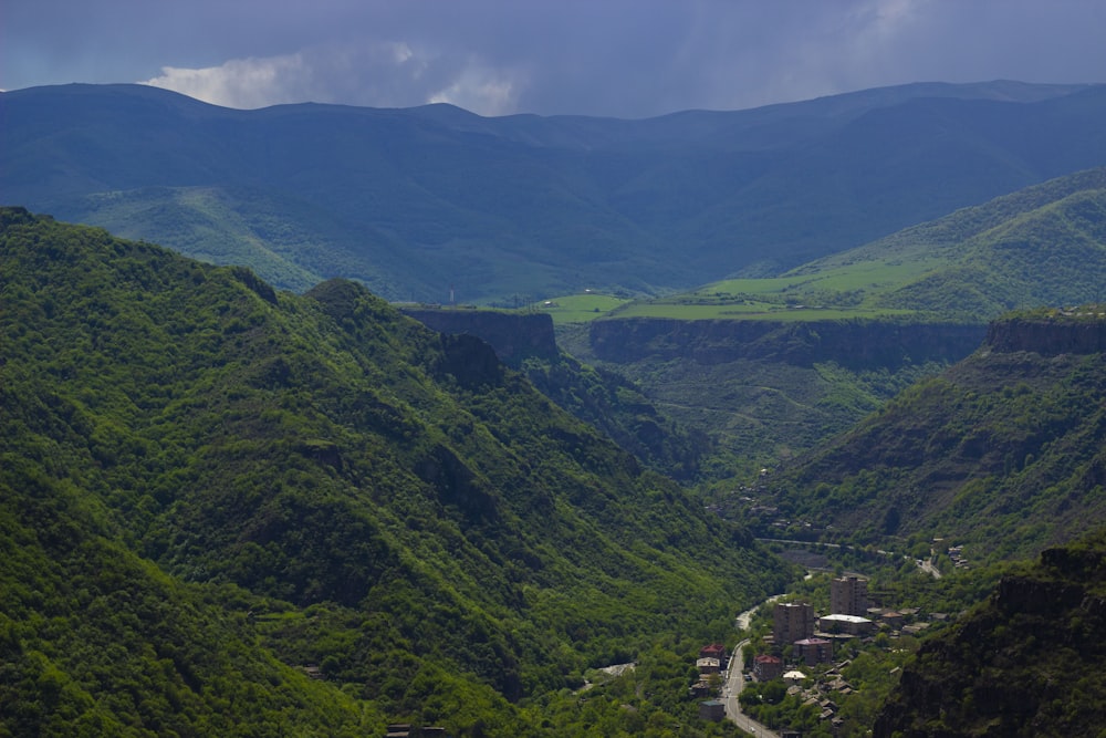 a scenic view of a valley with mountains in the background