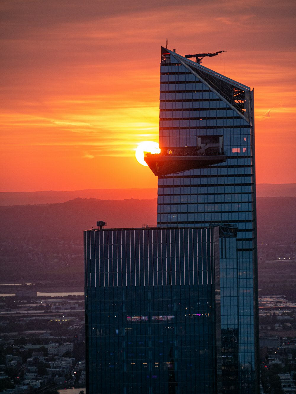 the sun is setting behind a tall building