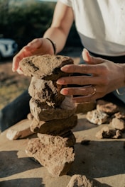 Close-up of hands carefully packing green slate stones with protective materials.