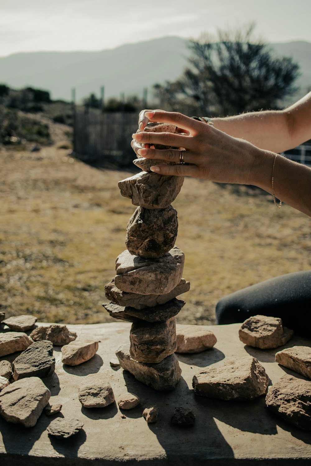 a person stacking rocks on top of a table