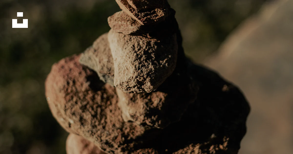 Rust Stack Of Rocks A stack of rocks sitting on top of a cement slab photo – Free Rust ...