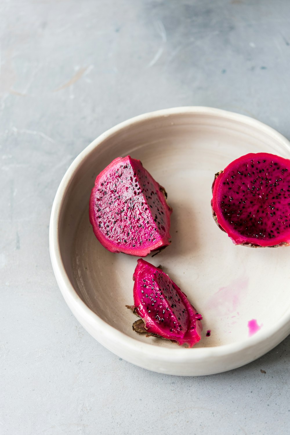 a white bowl filled with cut up pieces of fruit