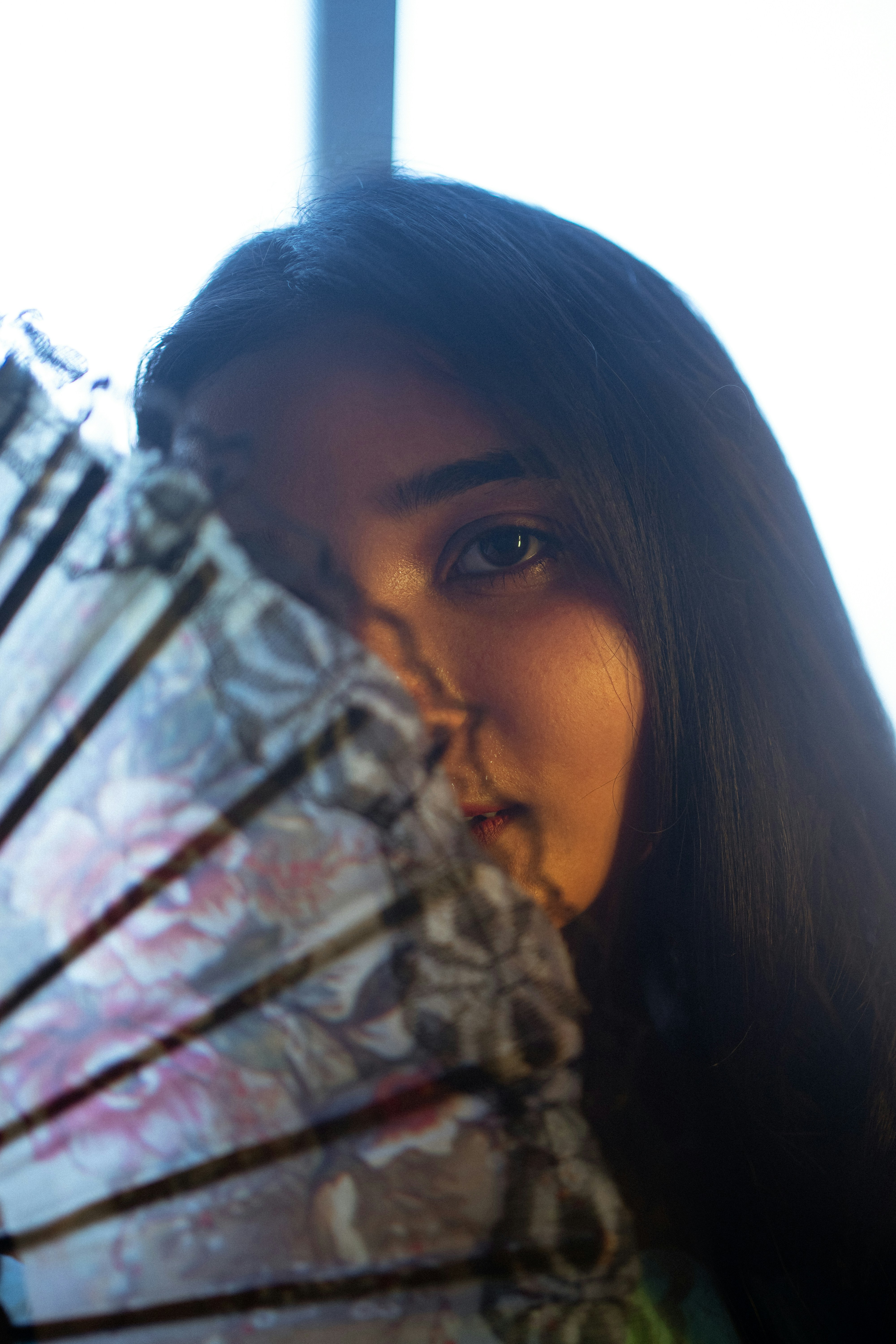 a woman holding an umbrella in front of her face