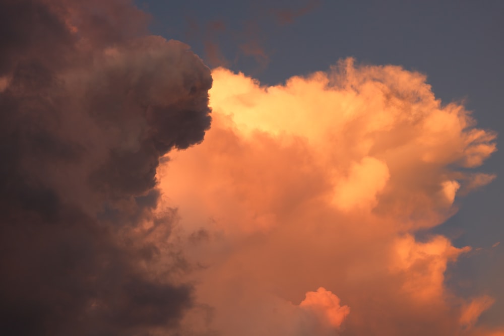 a plane flying through a cloudy sky at sunset