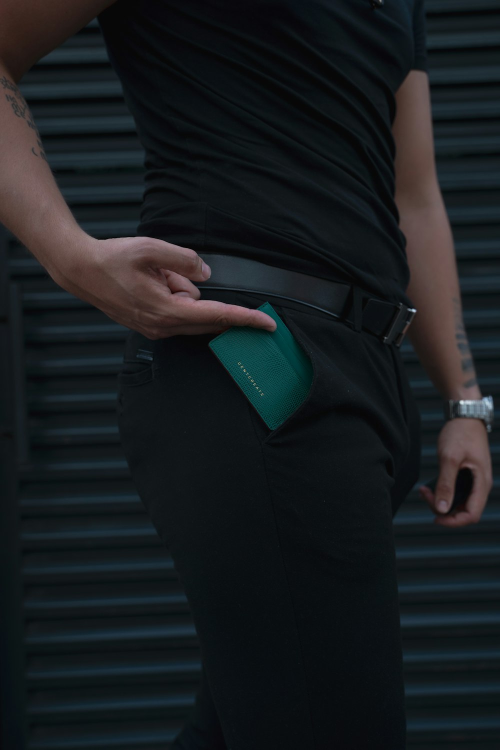 a person wearing a black shirt and a green wallet