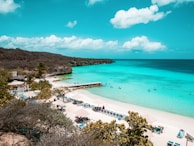 The sparkling turquoise waters of the French Riviera with sunbathers relaxing on the sandy beach.