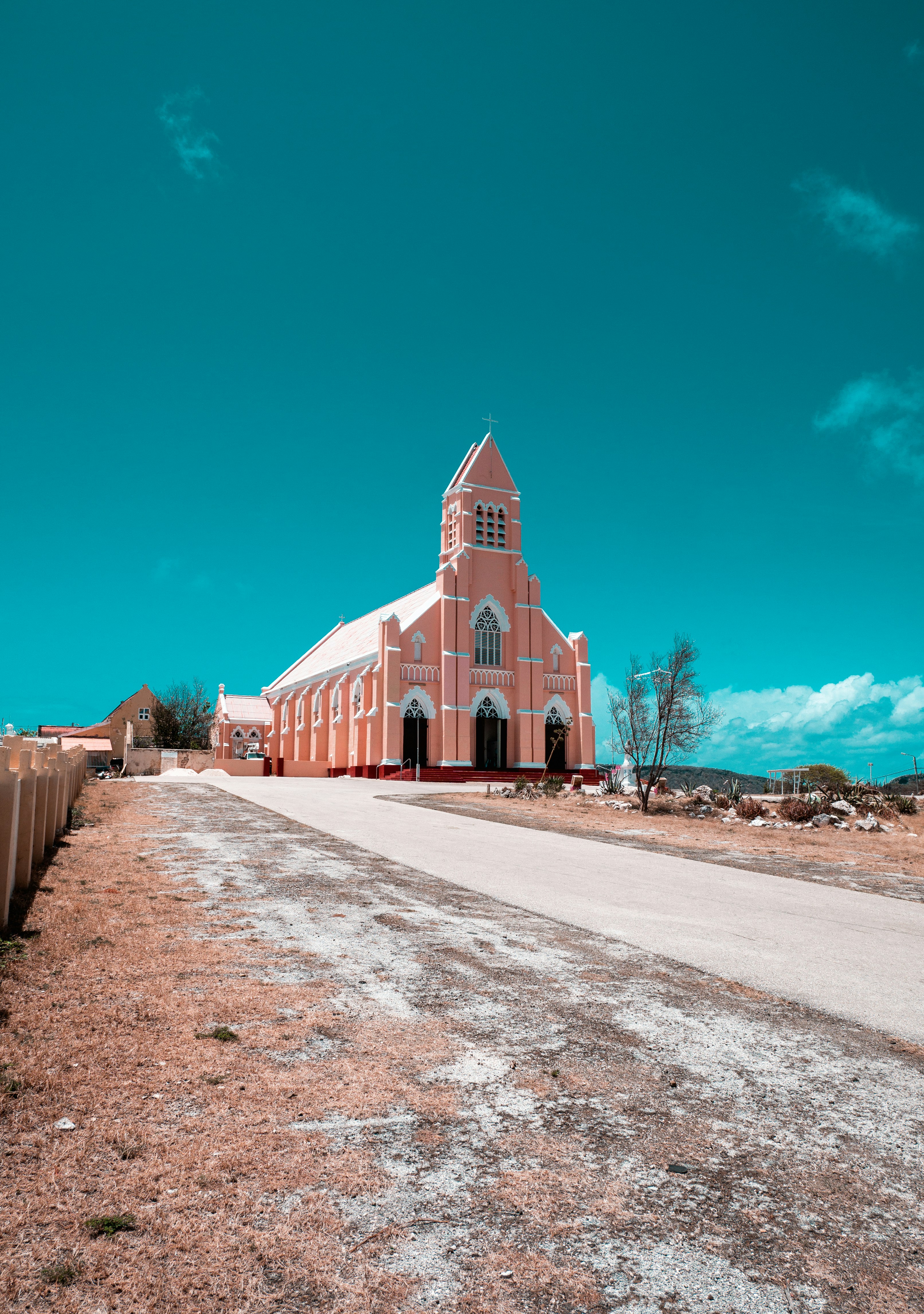 a large pink building with a cross on the top of it