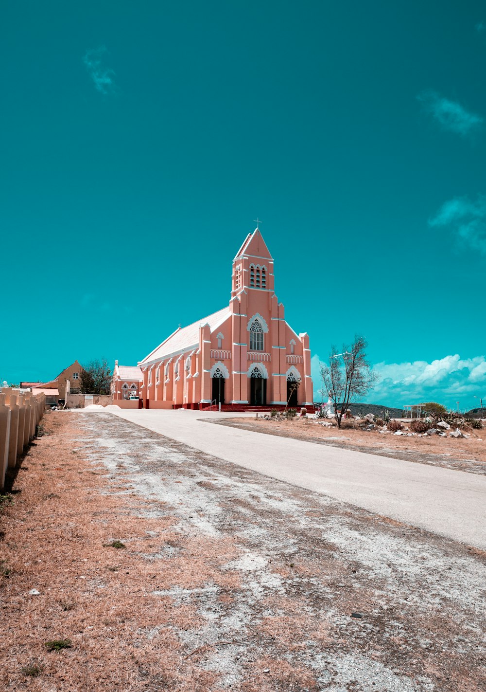 a large pink building with a cross on the top of it