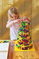A child carefully fitting together a complex geometric puzzle on a bright table.