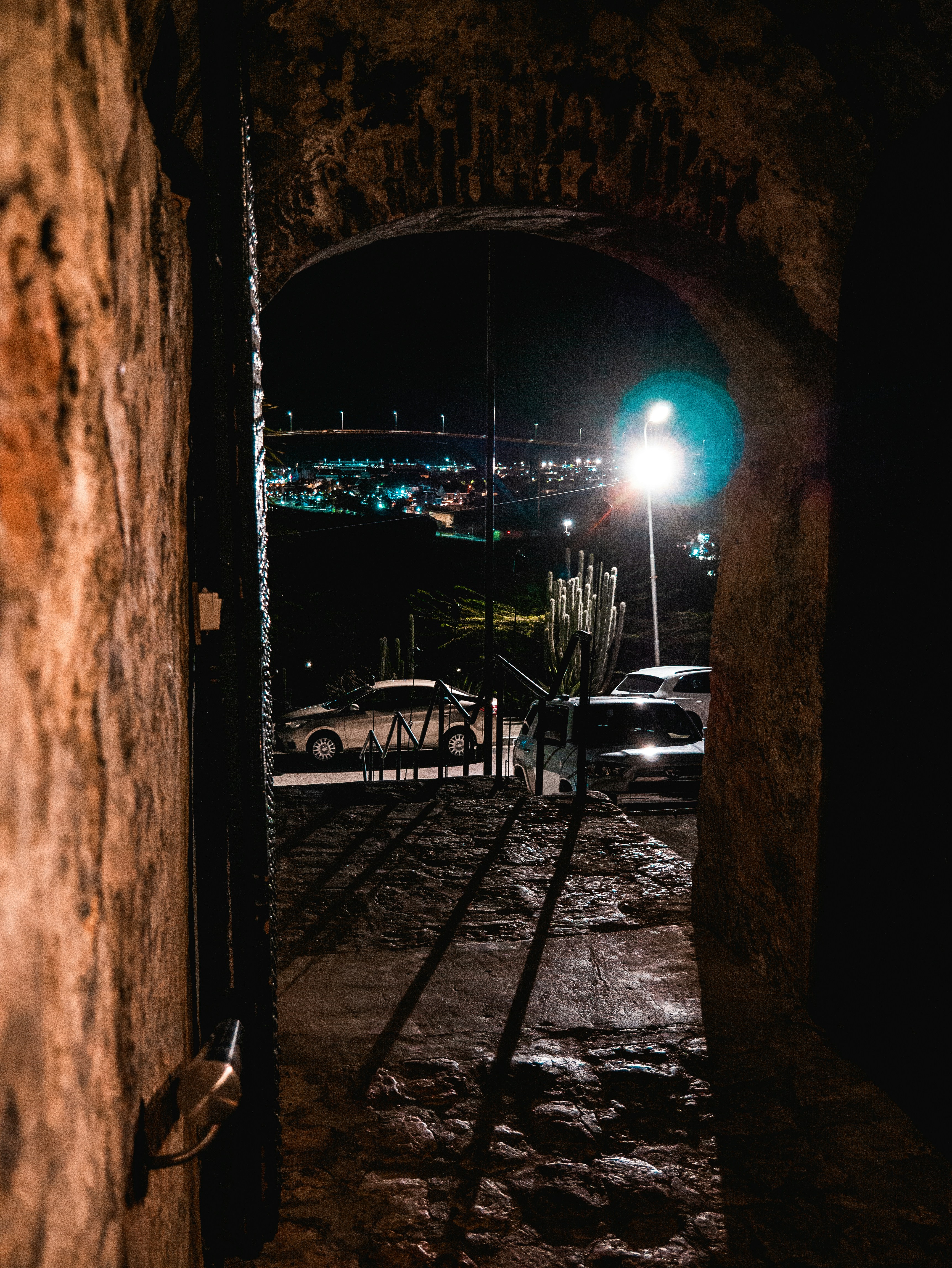 a dark tunnel with a street light in the distance
