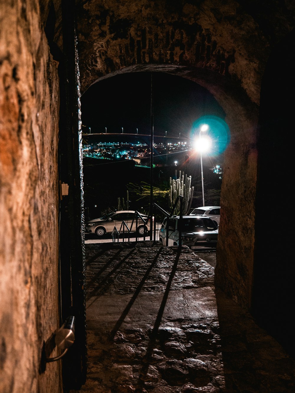 a dark tunnel with a street light in the distance