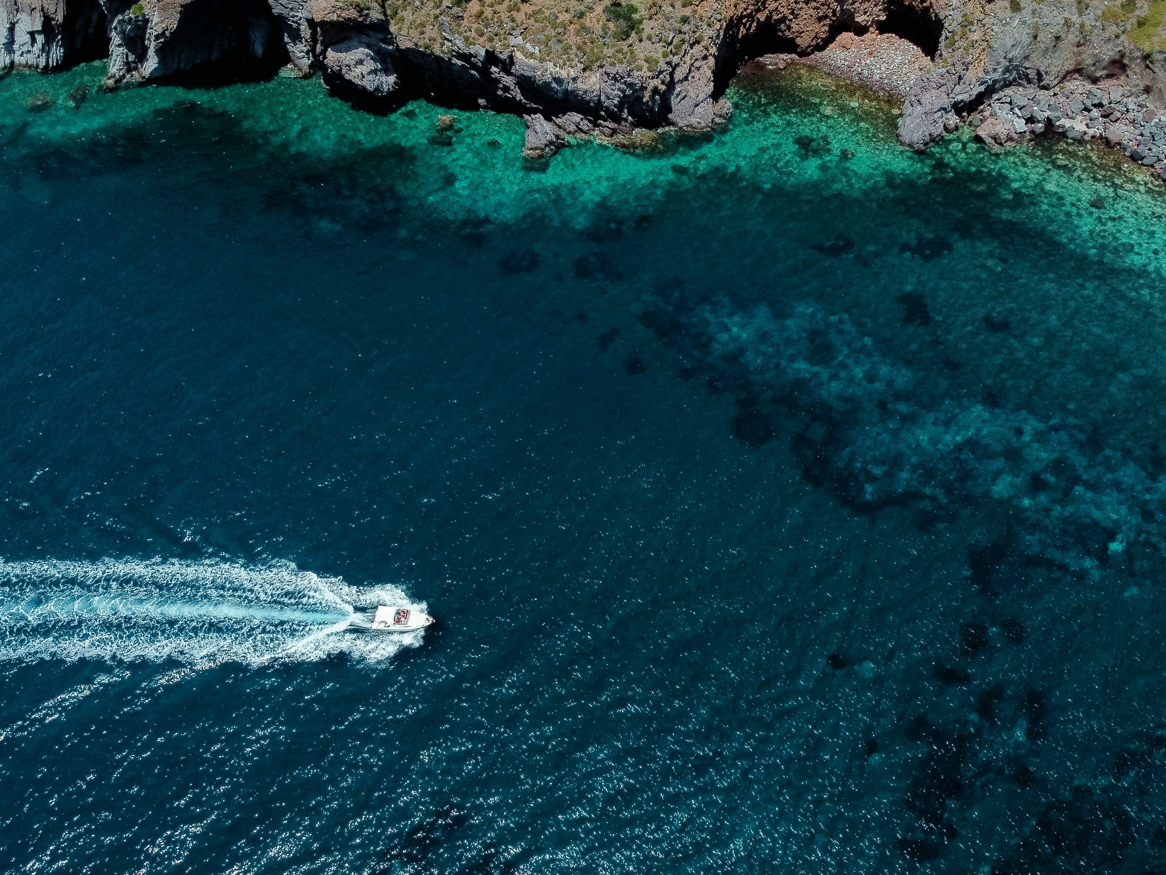 an aerial view of a boat in a body of water, 
