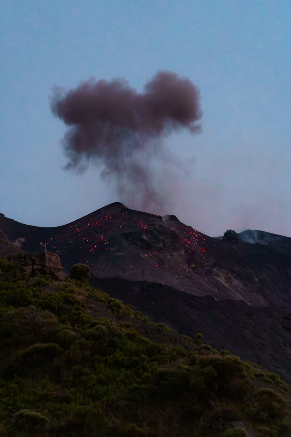 a large plume of smoke rising from the top of a mountain