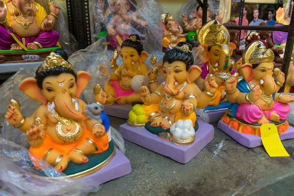 A collection of brass Ganesha idols in various sizes displayed on a rustic table.