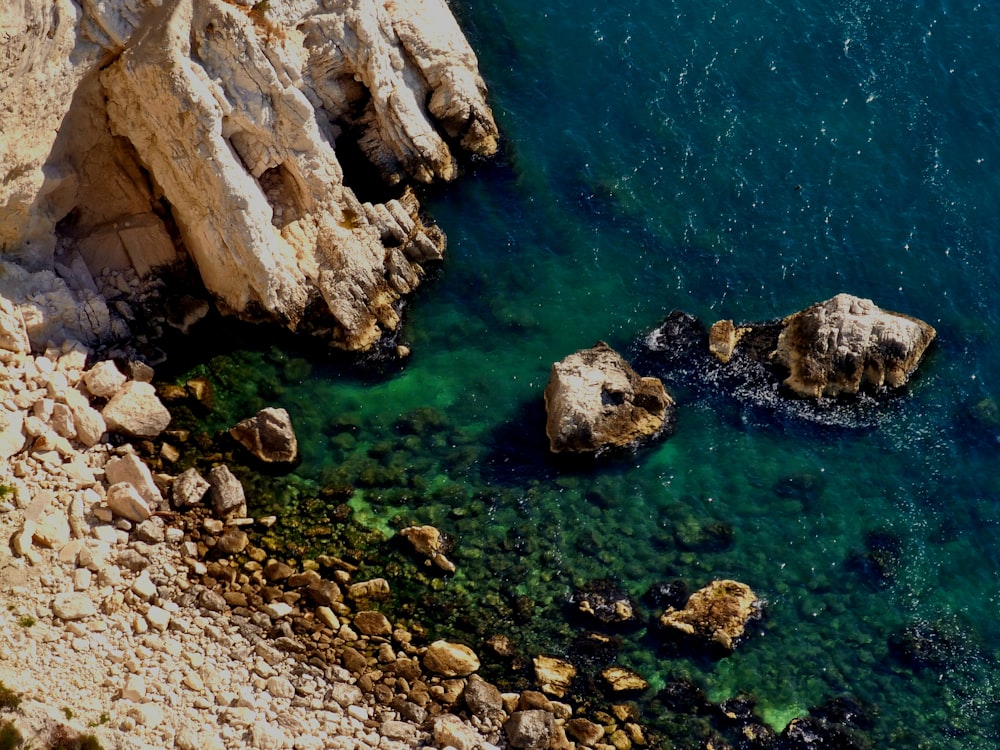 a body of water surrounded by rocks and a cliff