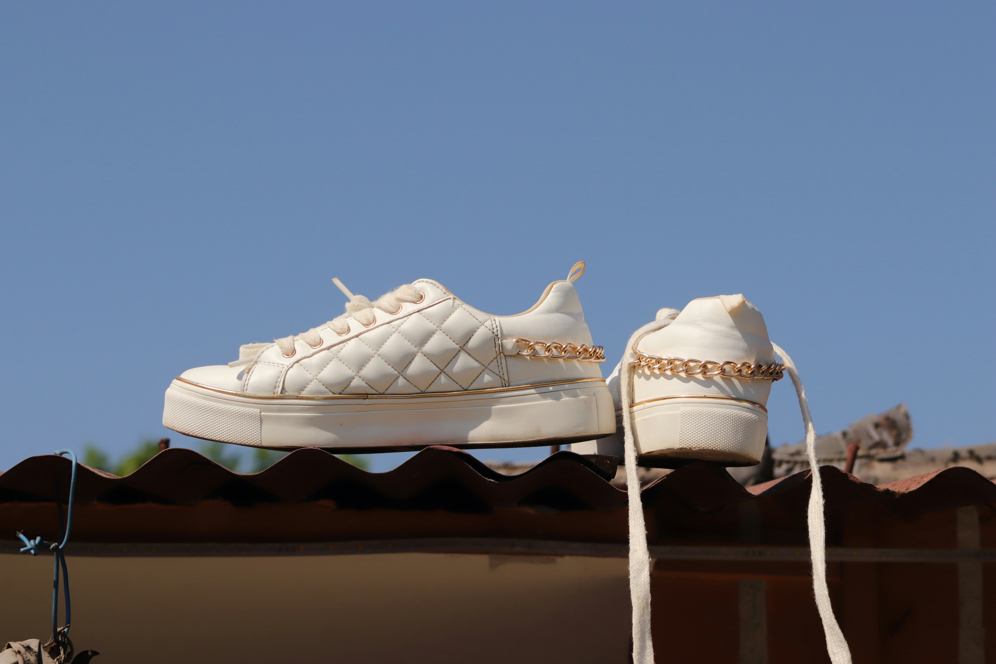 a pair of white sneakers on top of a roof