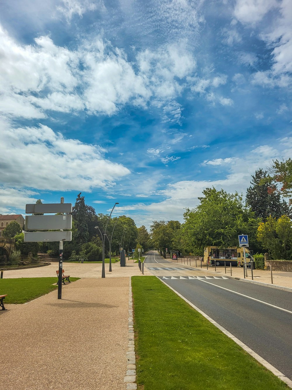 a street with a sign and a bench on the side of the road