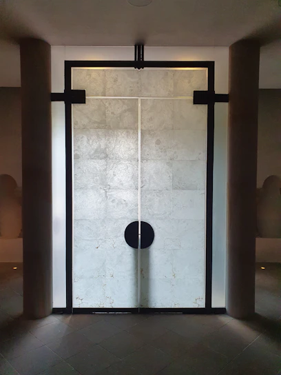 A matte black premium steel security door with brushed steel accents set against a modern villa entrance.