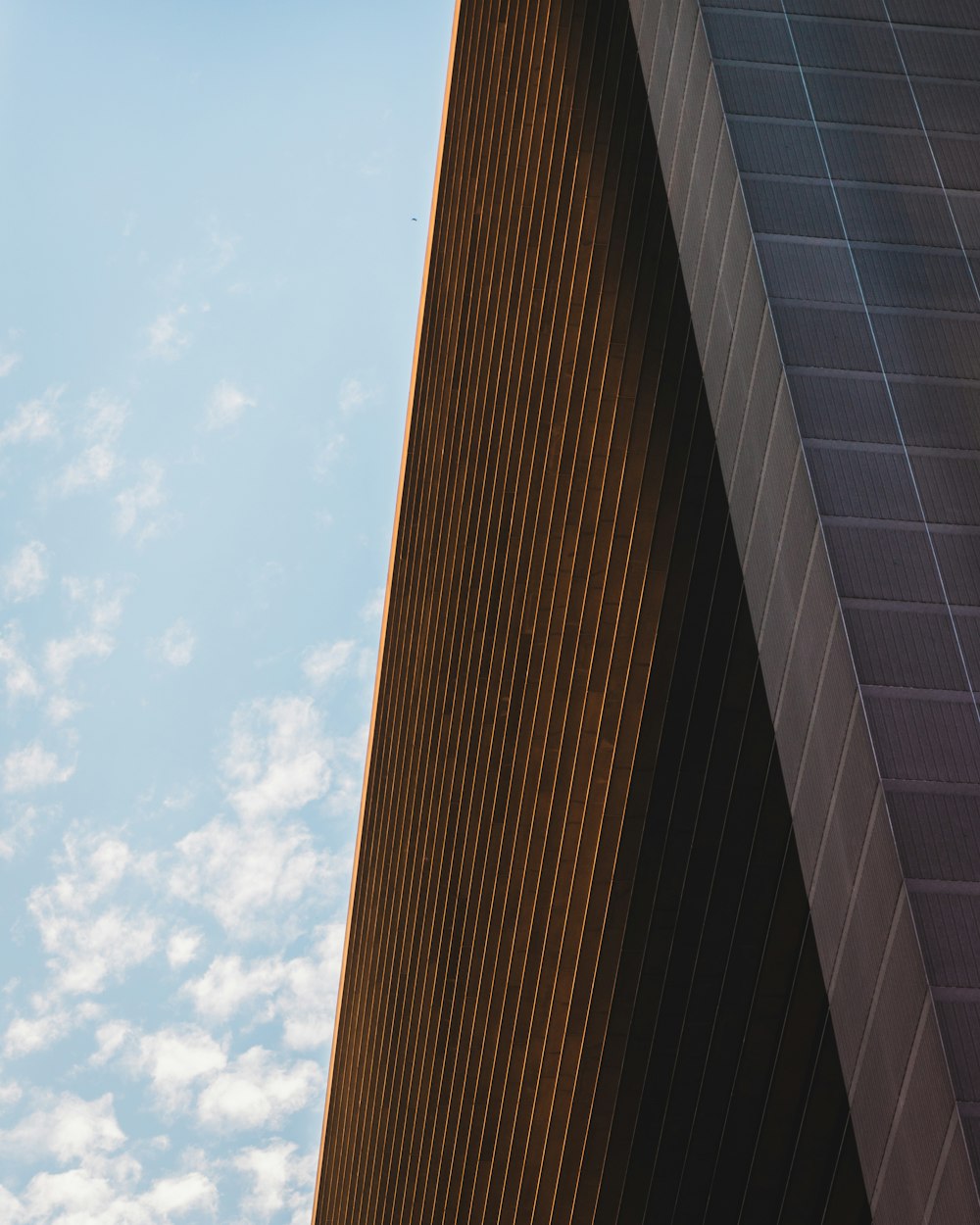 a plane flying in the sky over a building