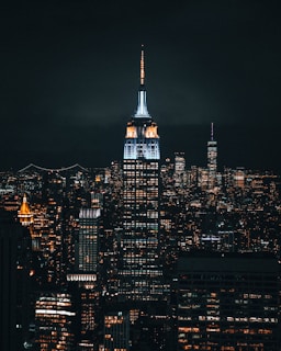 A nighttime city skyline with a person in Lumina Apparel gear standing on a rooftop, highlighting the brand’s connection to city life.